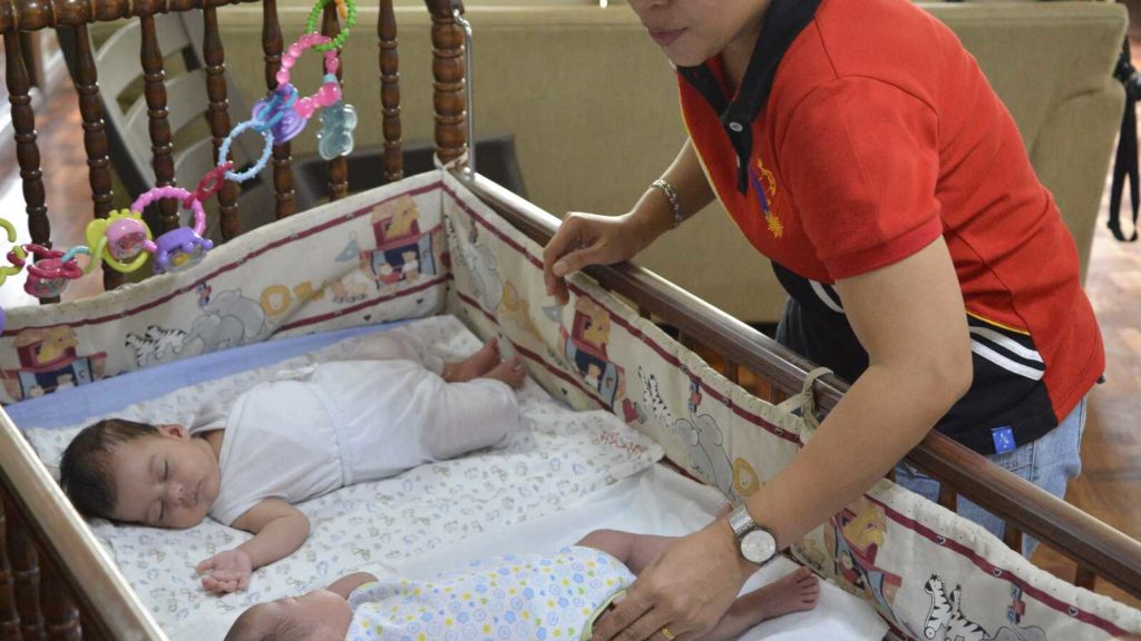 caretaker comforting sleeping babies