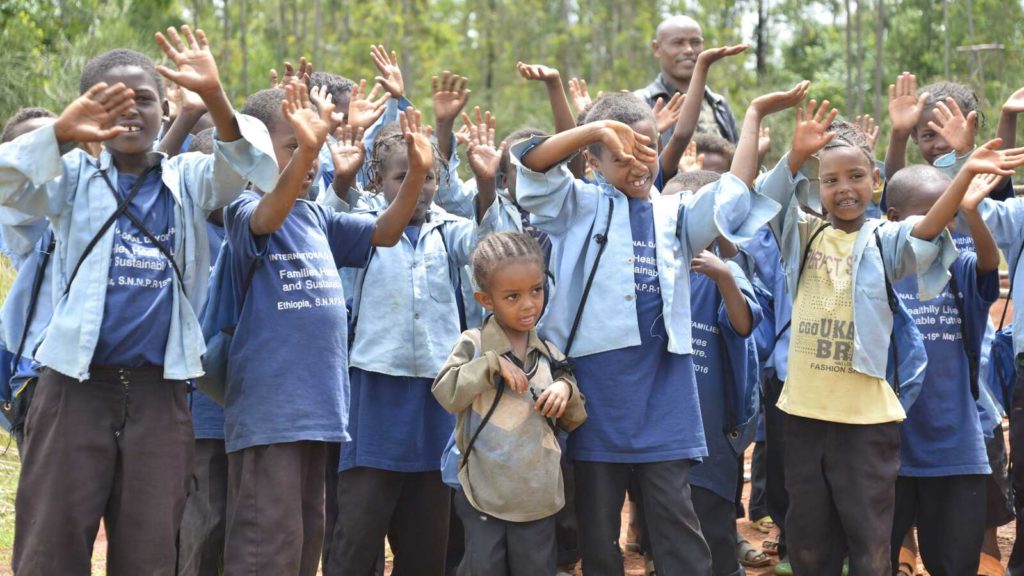 Group of kids raise hands in Ethiopia