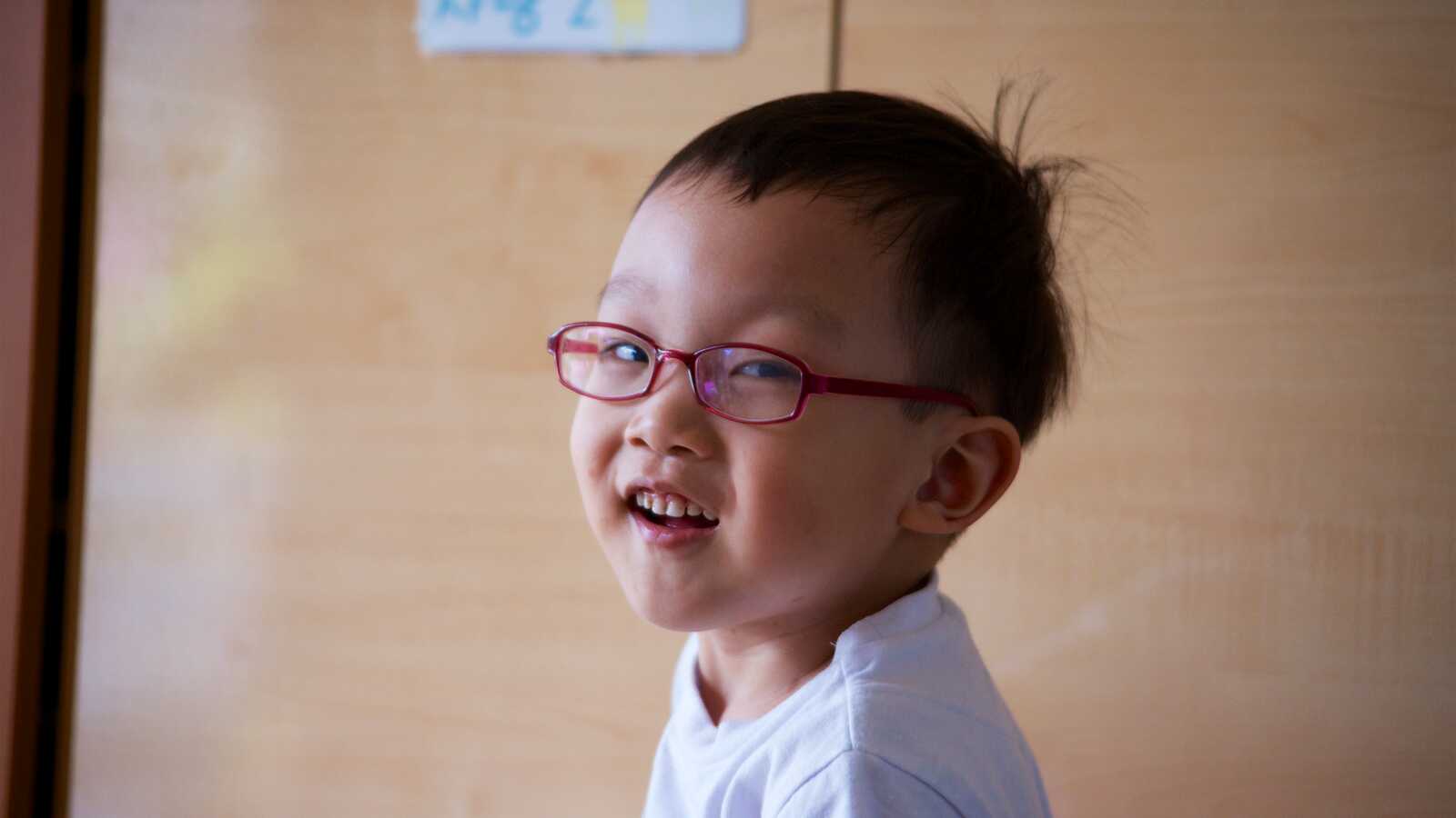 Korean toddler wearing red eye glasses