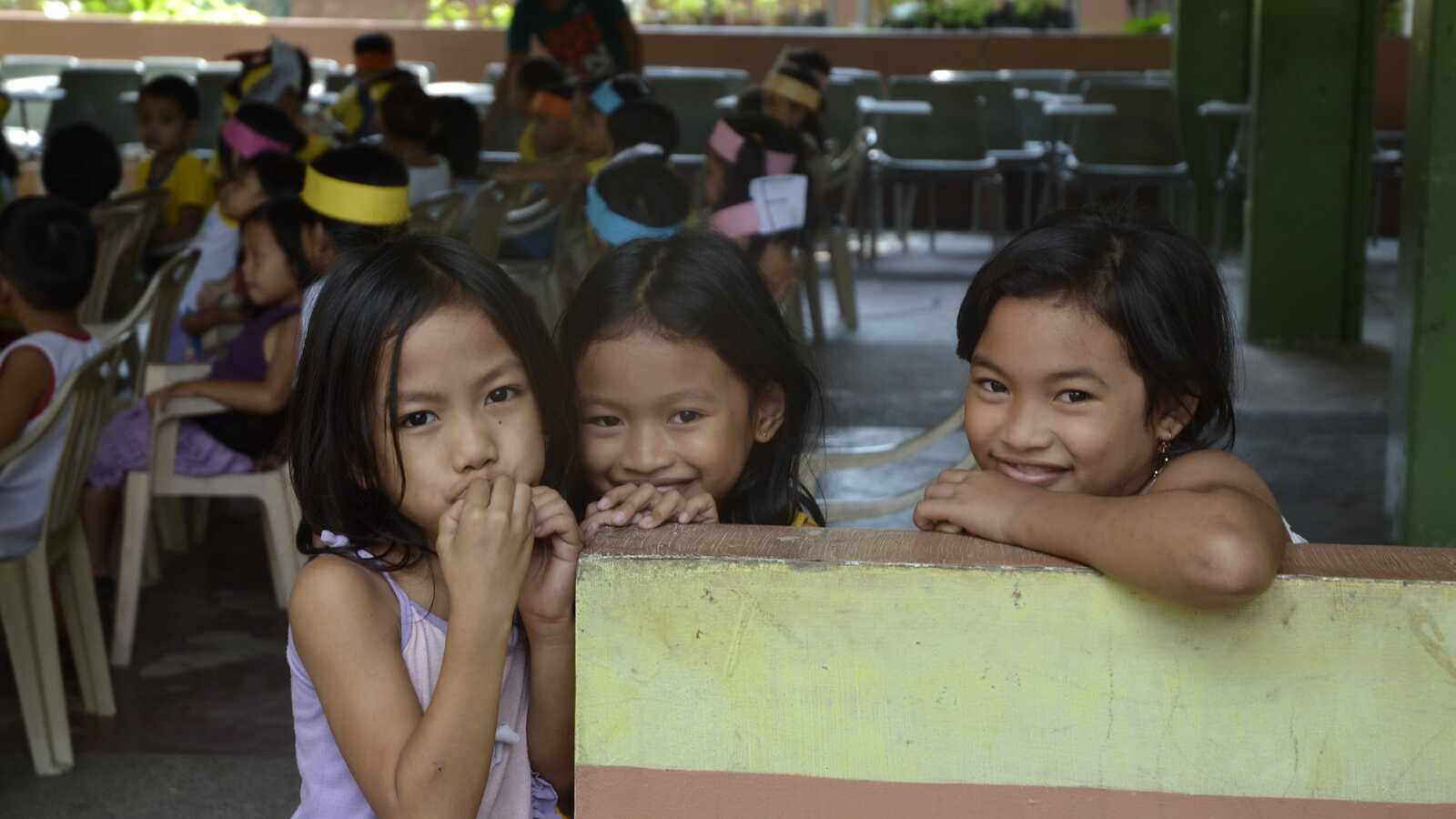 three girls smile for photo in the Philippines
