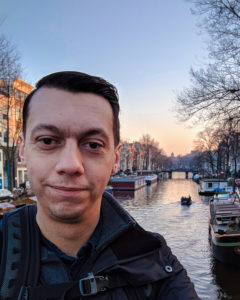 man looking at camera standing in front of river
