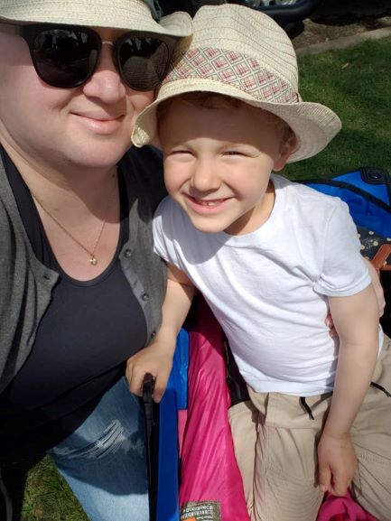 smiling woman in sunglasses with smiling boy in hat