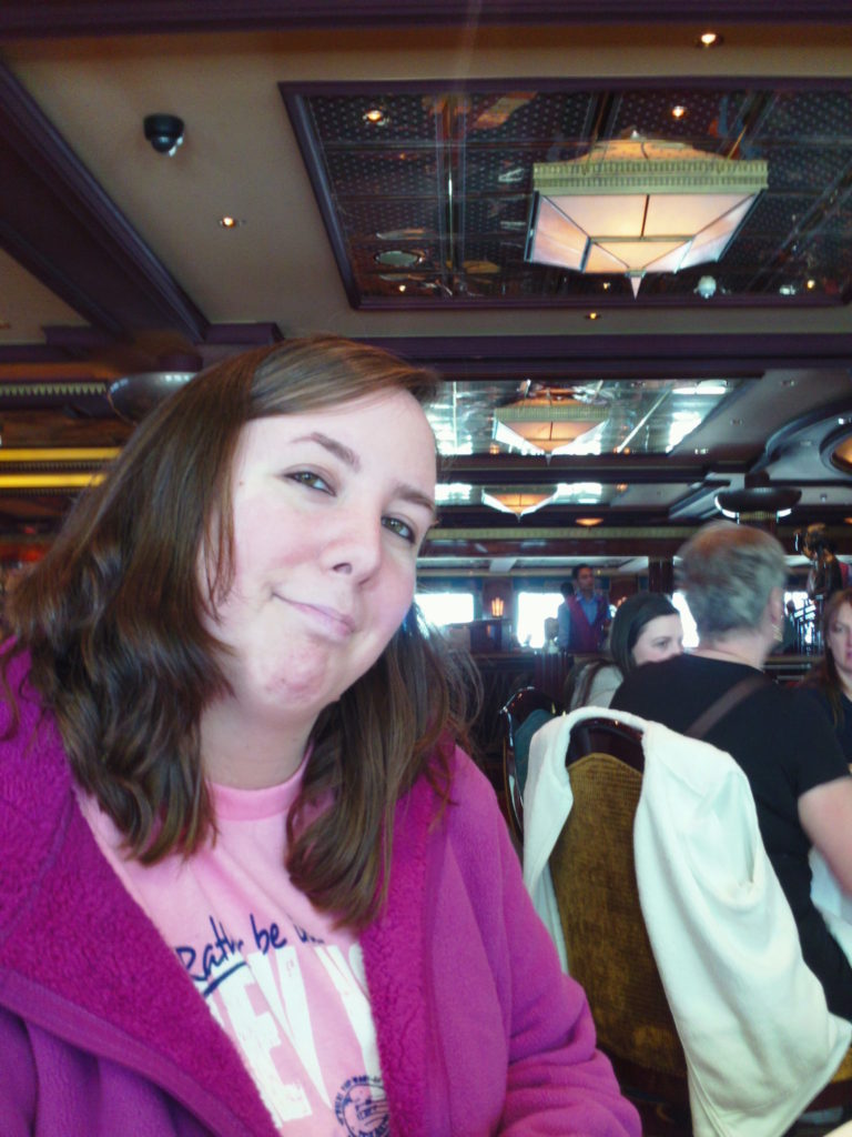 smiling brunette woman wearing fuschia jacket and pink shirt