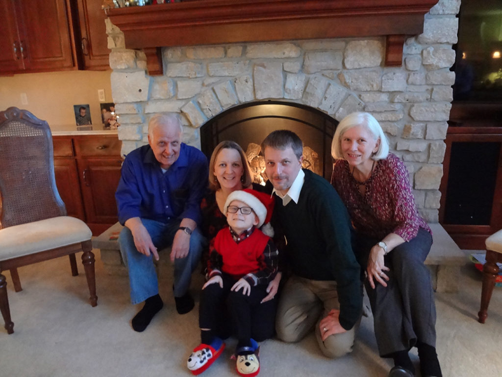 smiling group of people sitting in front of stone fireplace