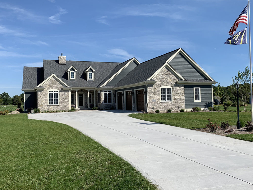 two story green and white stone house
