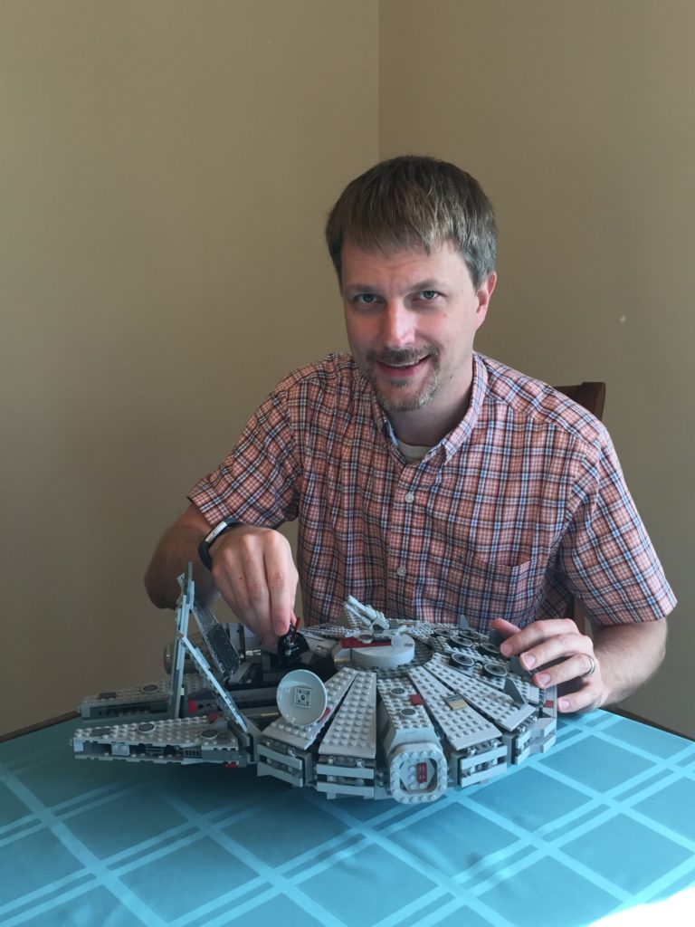 smiling man working on lego model