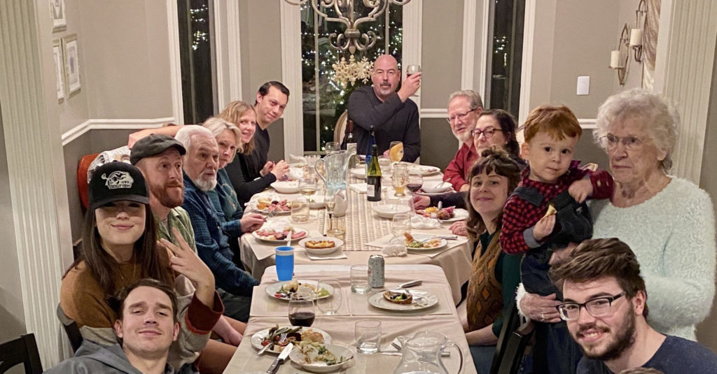 group of people sitting at long table for dinner