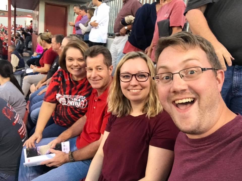 selfie of four people in the crowd of a football game
