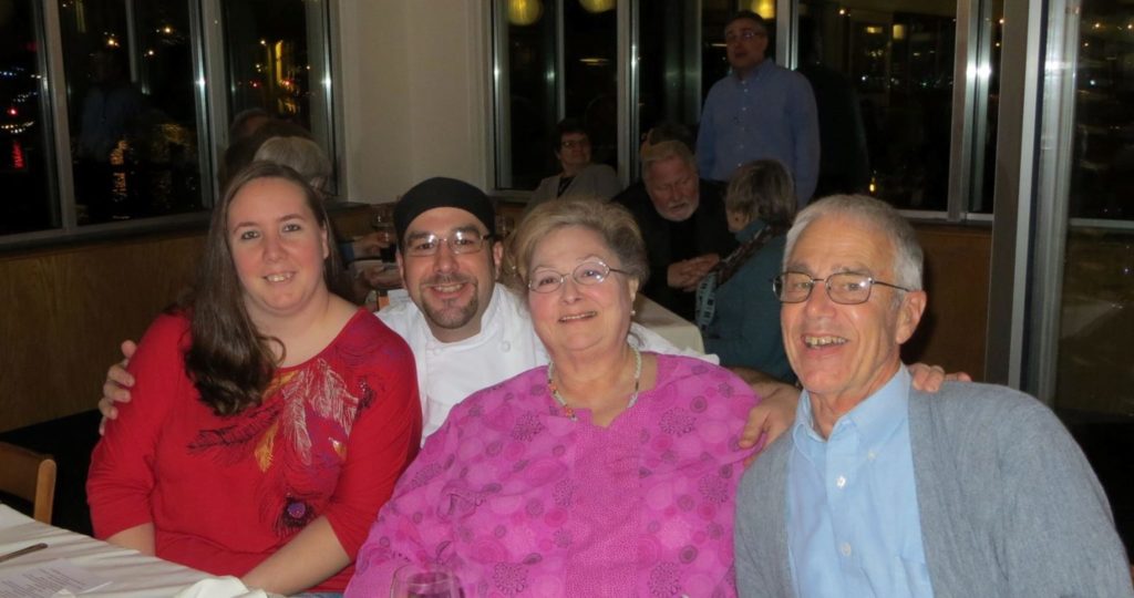 four smiling people at a restaurant