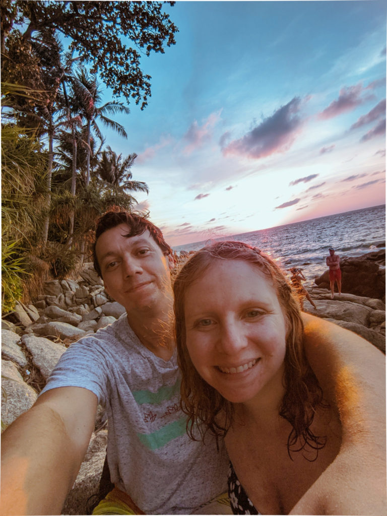 man with his arm around a woman on the beach