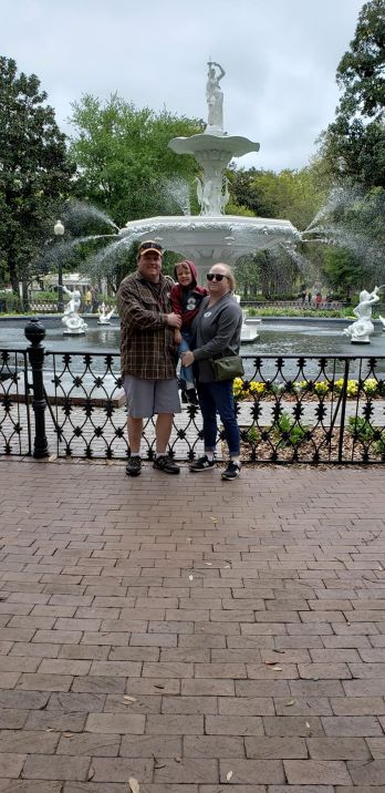 dad mom and son standing in front of elaborate water fountain