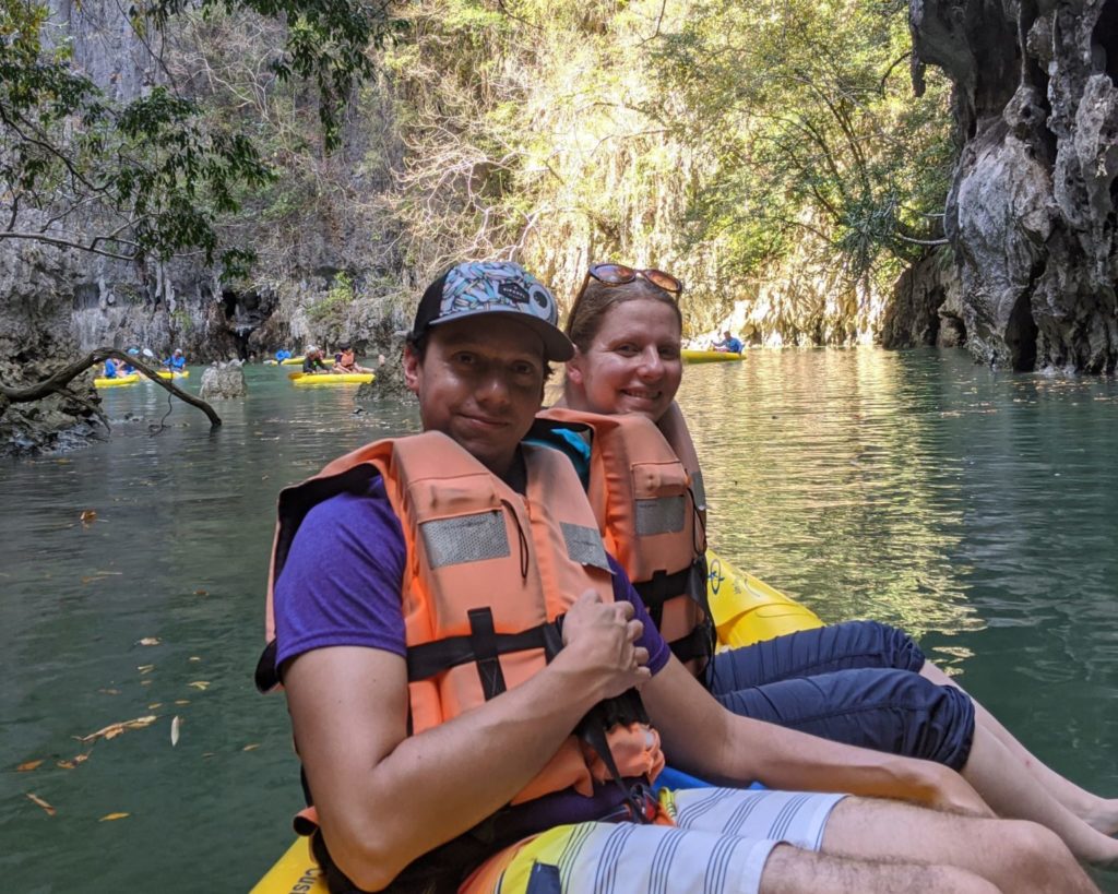 man and woman sitting in kayak wearing orange lifejackets
