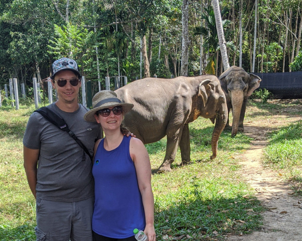 man and woman standing in front of two elephants