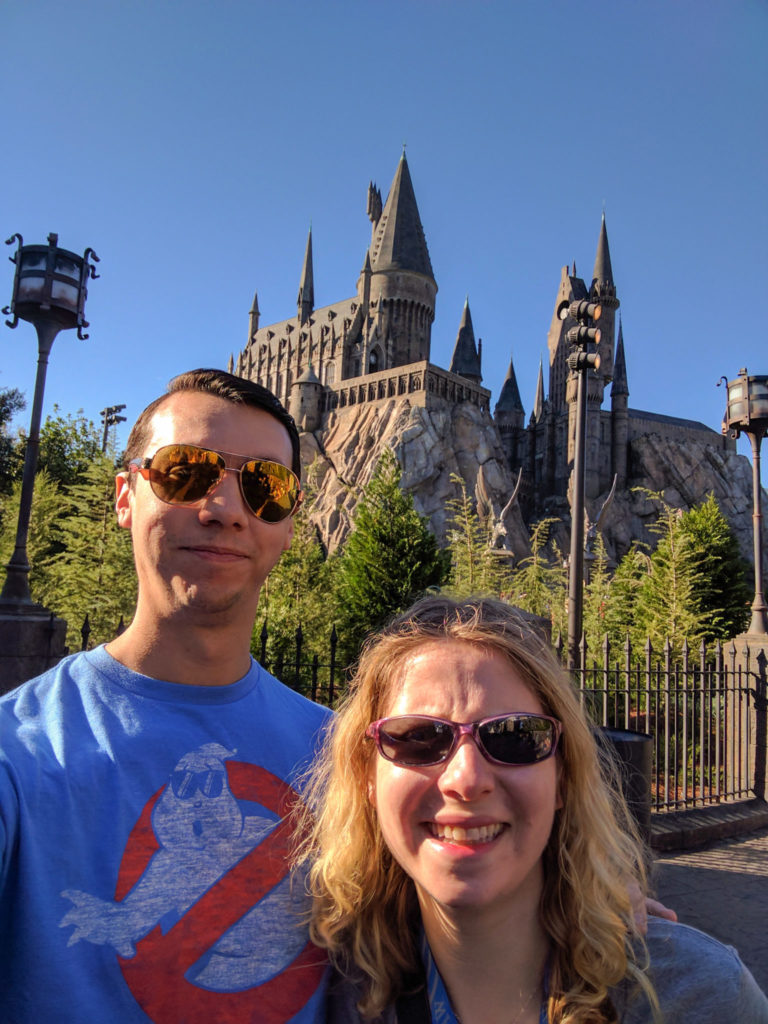 selfie of man and woman in front of grey stone castle