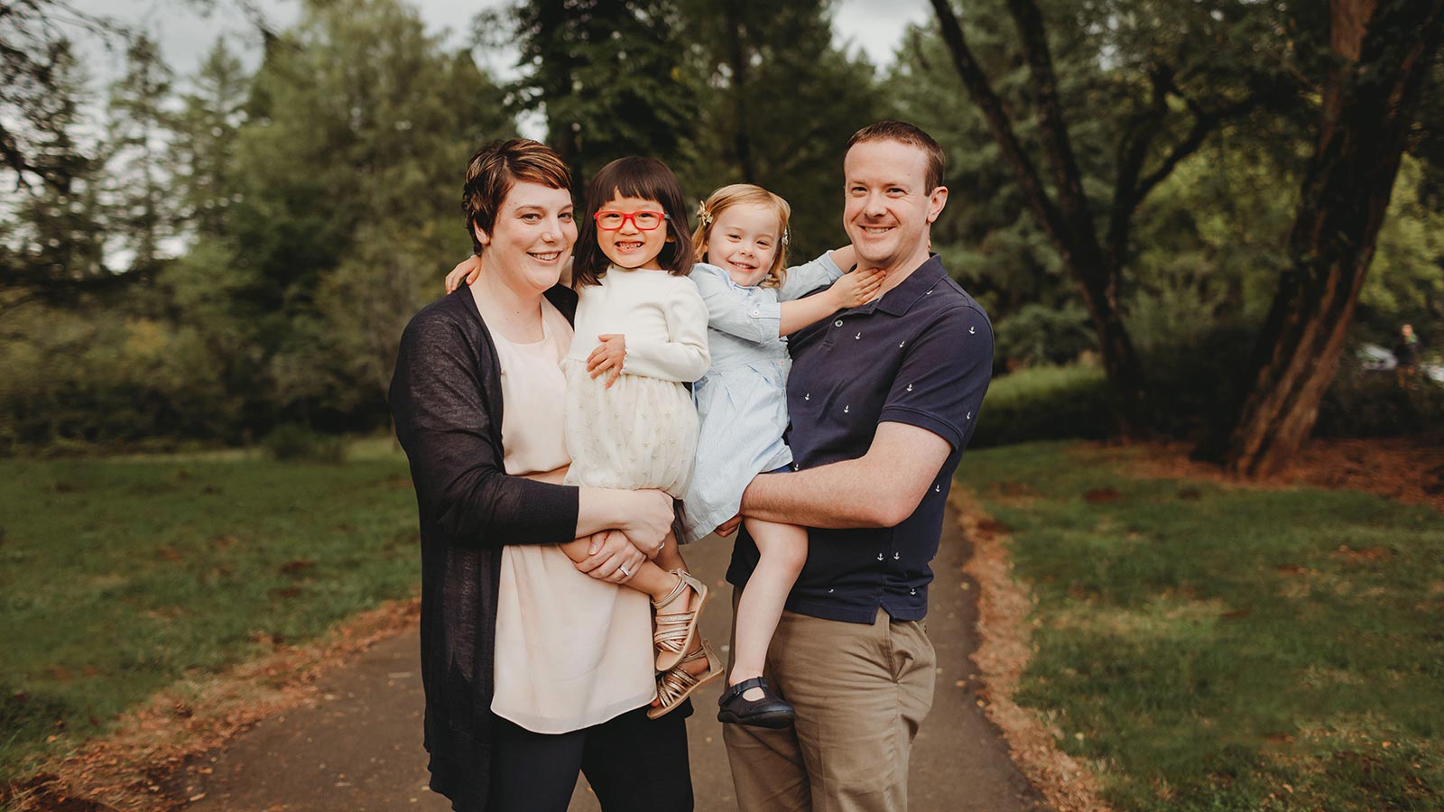 photo of adoptive family with adoptive parents holding two daughters