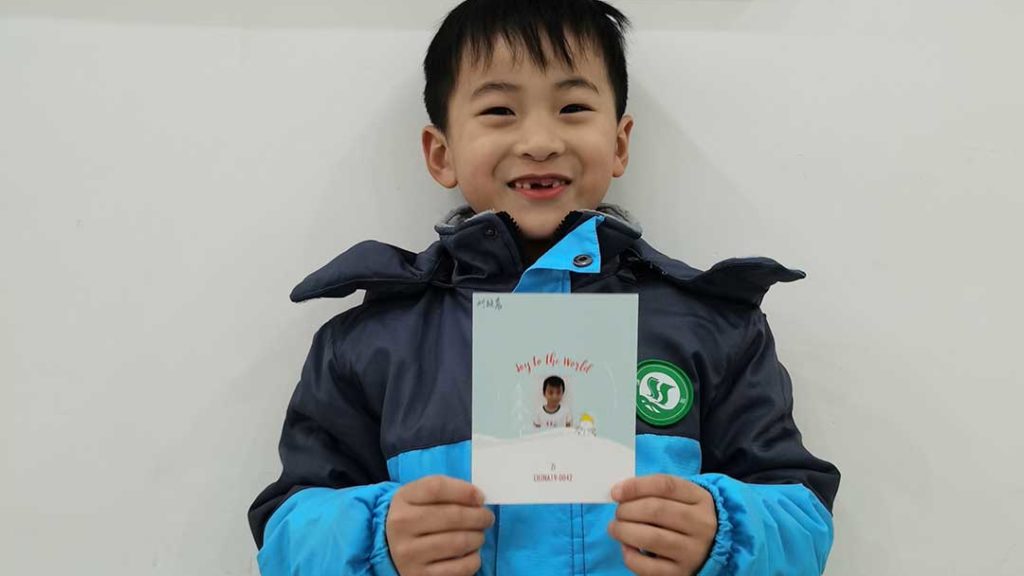 boy smiling with Christmas card