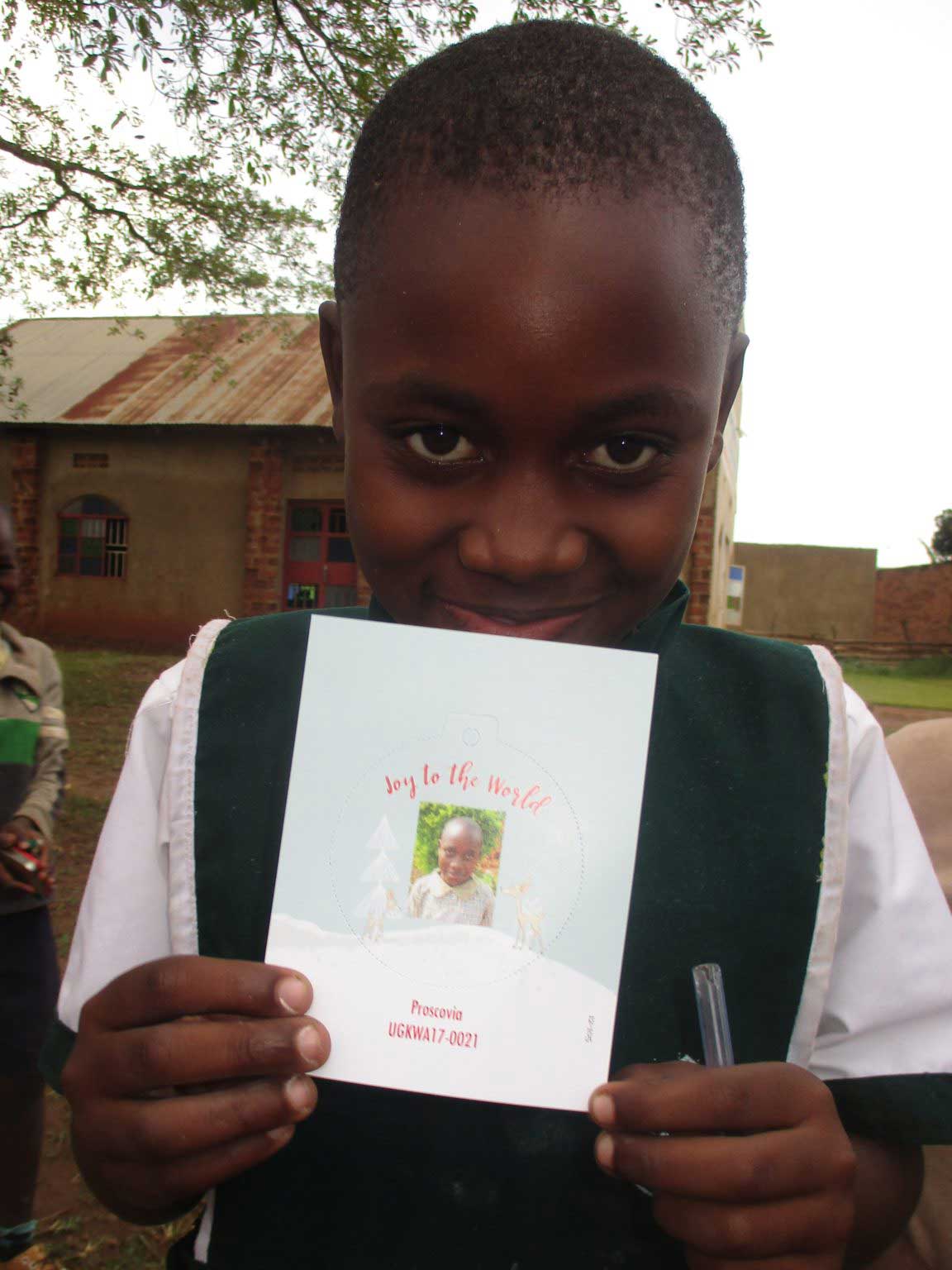 Boy smiling with Christmas card in Uganda