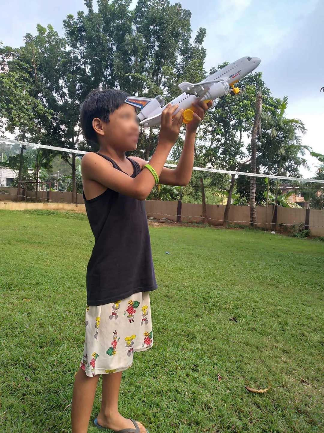 Boy play with toy plane in India