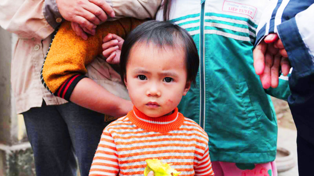 boy standing in front of his family