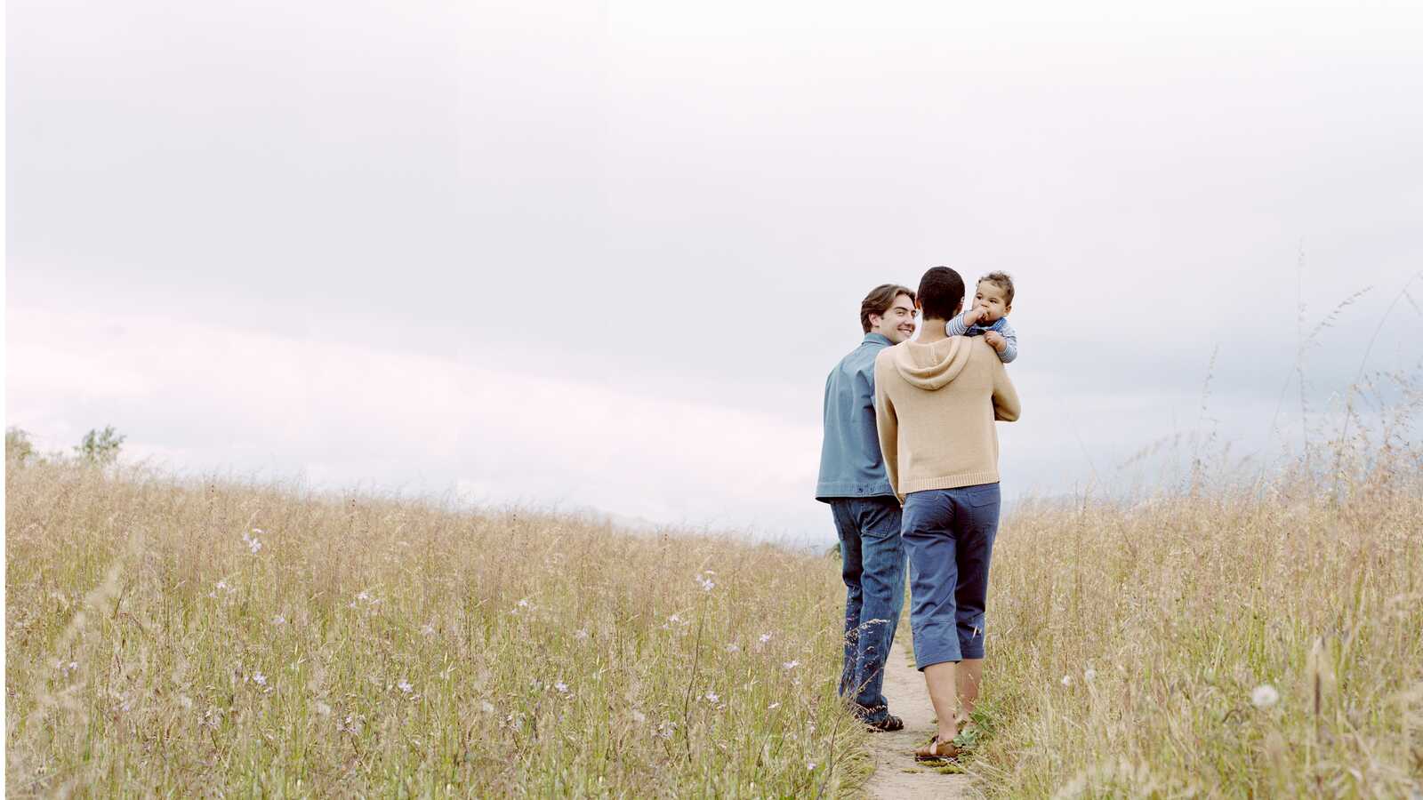 couple walking down path holding adopted baby