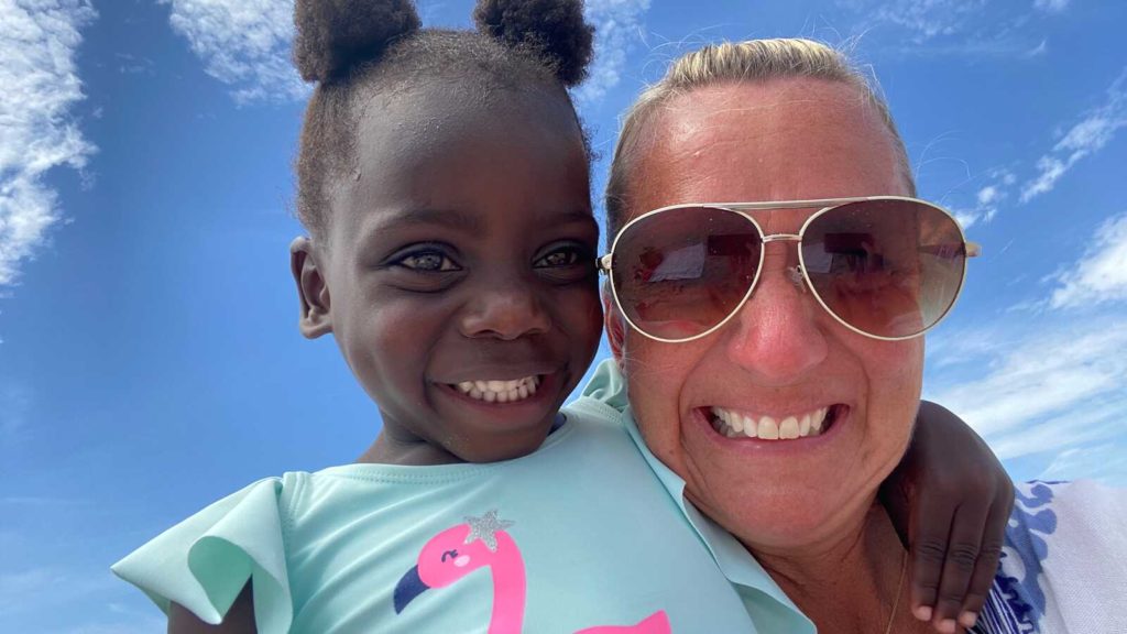 mother smiles with adopted daughter from Haiti