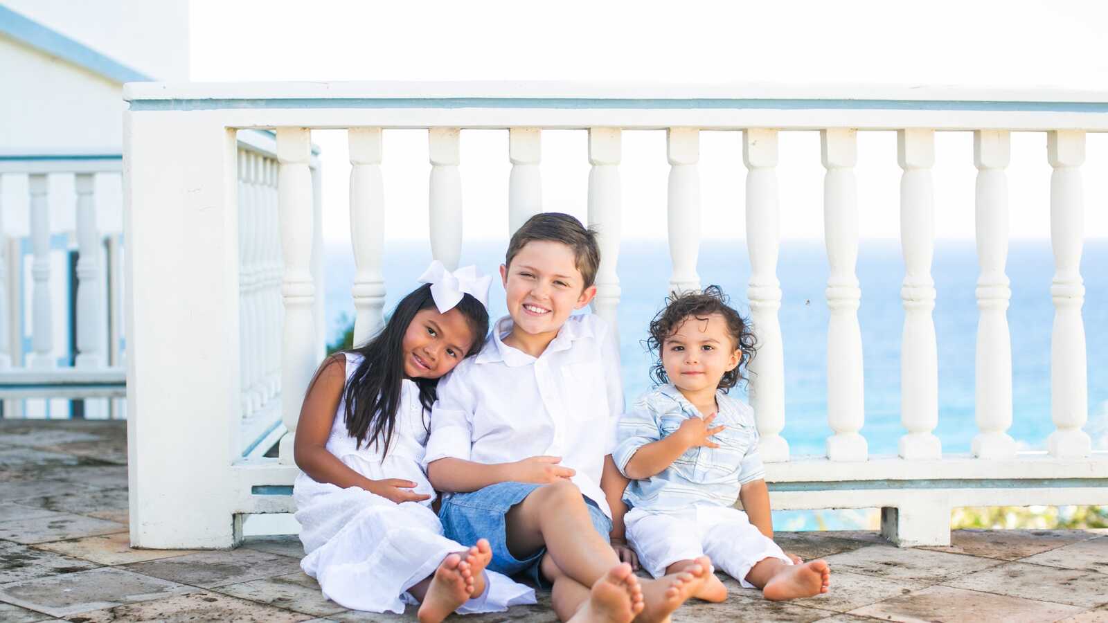 adopted siblings from Korea smiling with older brother