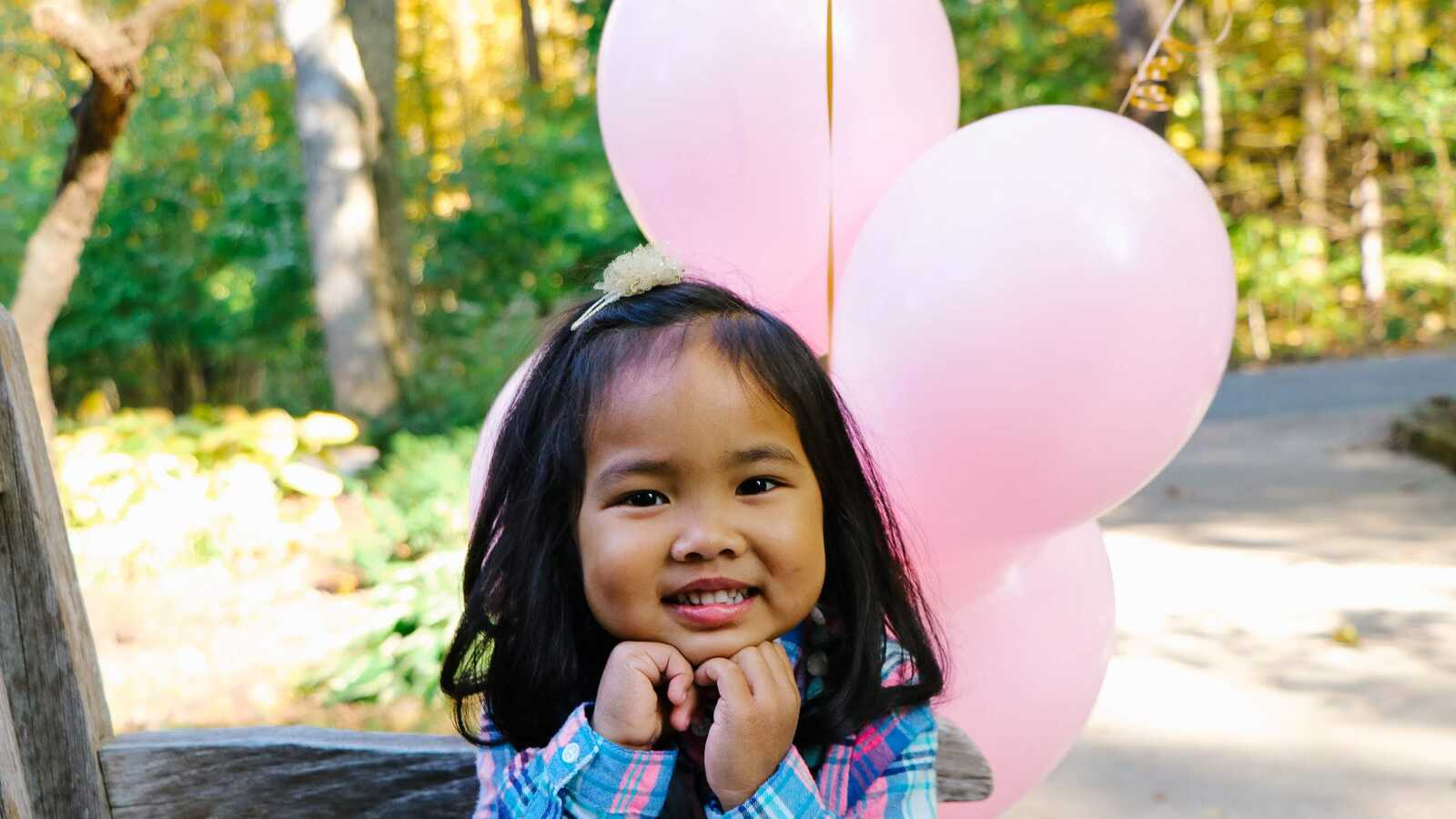 girl smiling with pink balloons