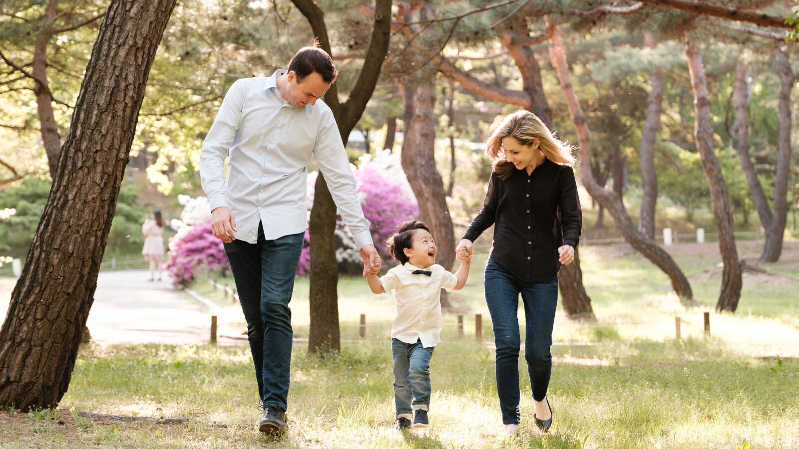 parents holdings hands with adopted Korean son for family portrait