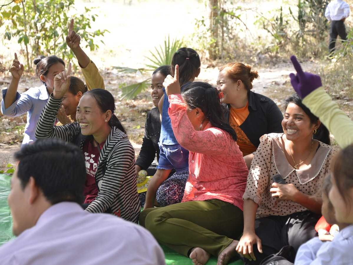 woman raise hands while sitting on rug