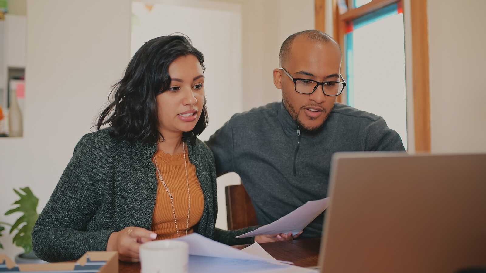 couple sitting at home viewing virtual adoption financing webinar on their laptop