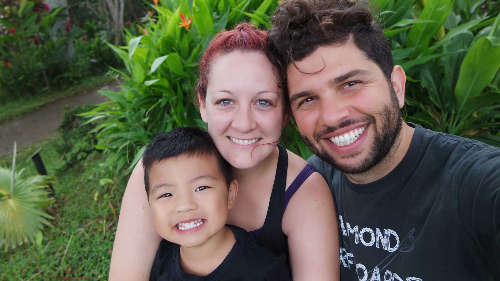 parents smile with adopted son from Thailand