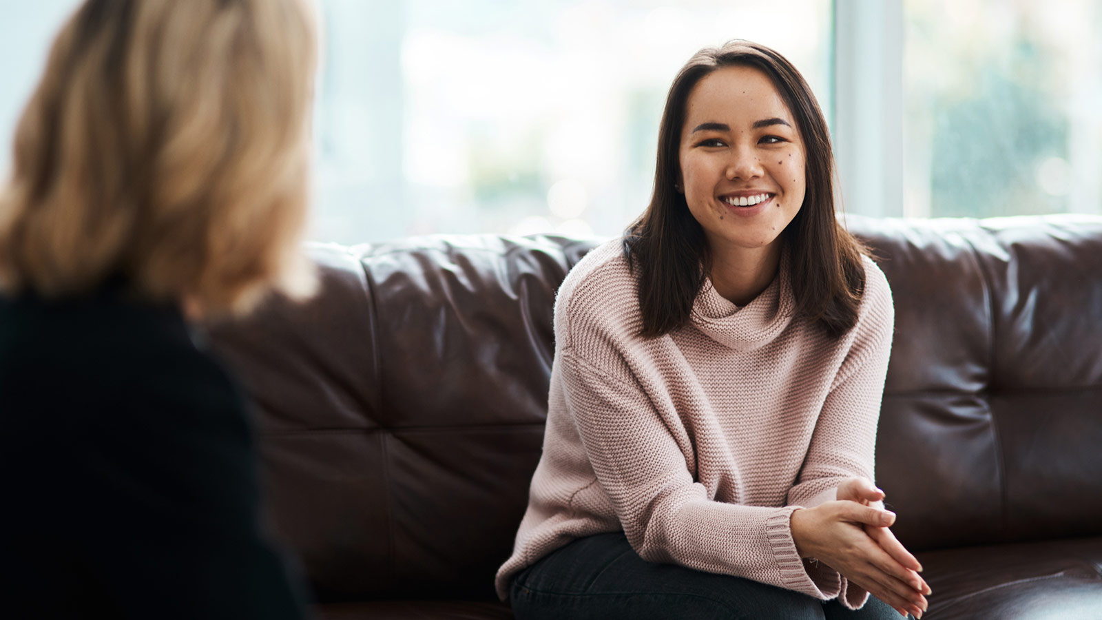 young woman smiling meeting with post adoption counselor