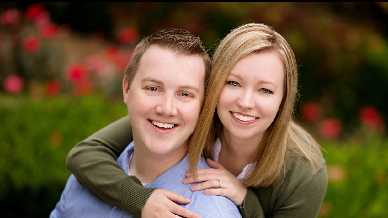 smiling blonde woman with arms around smiling man