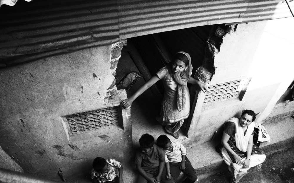 woman in India lookin up from doorway 
