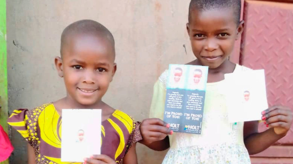 Two little girls with gifts from their sponsors