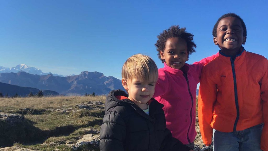 adopted children from Ethiopia climbing a mountain on a family hike