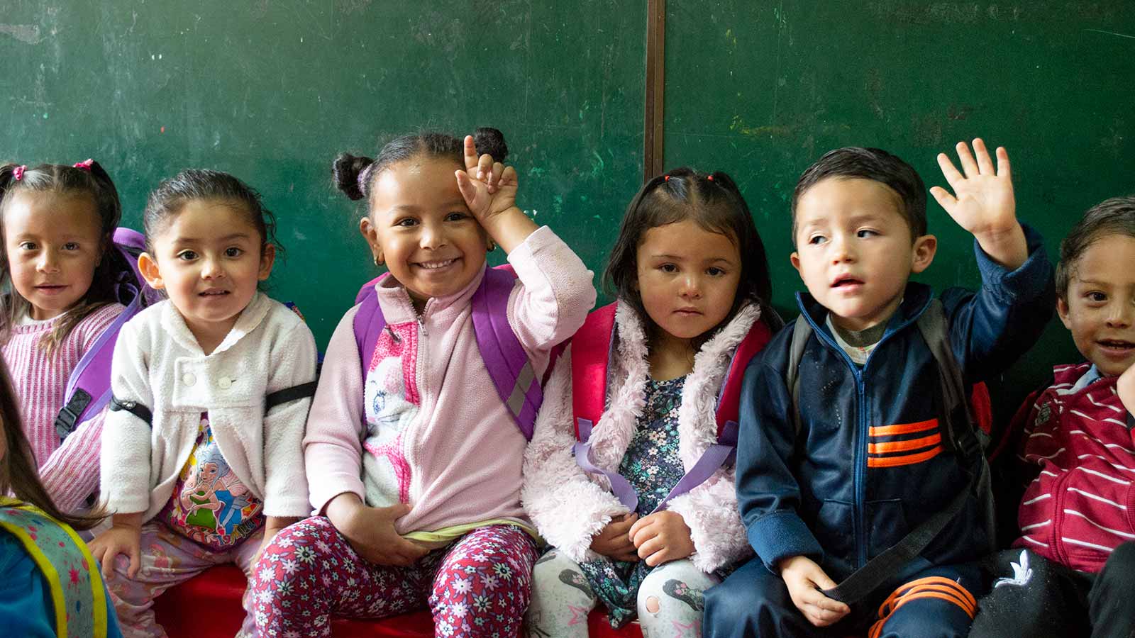 preschool children in Colombia waiting on a bench
