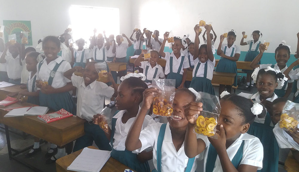 Children eat snacks in a classroom in Haiti