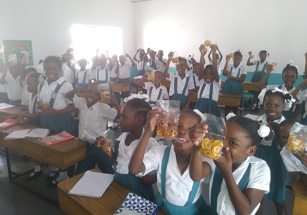 Children eat snacks in a classroom in Haiti