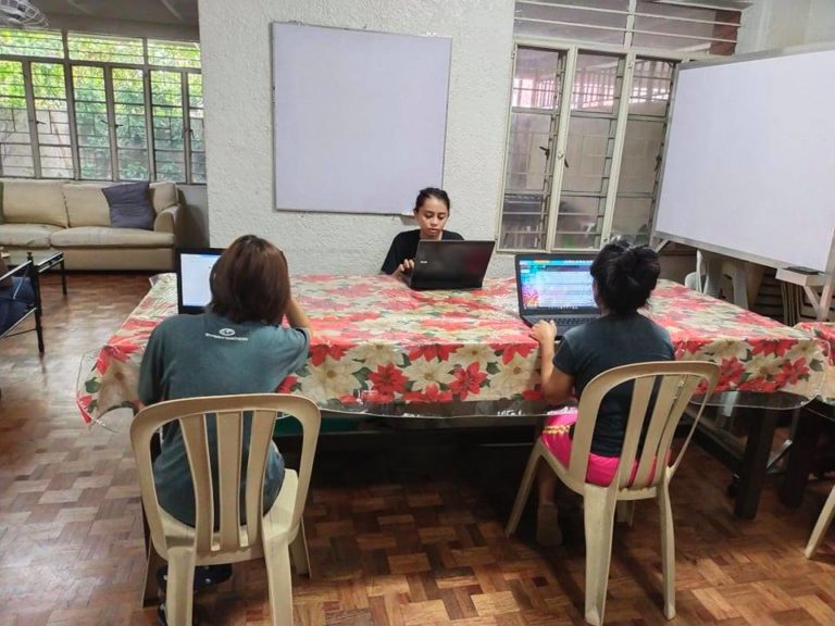 Children studying with laptops in classroom