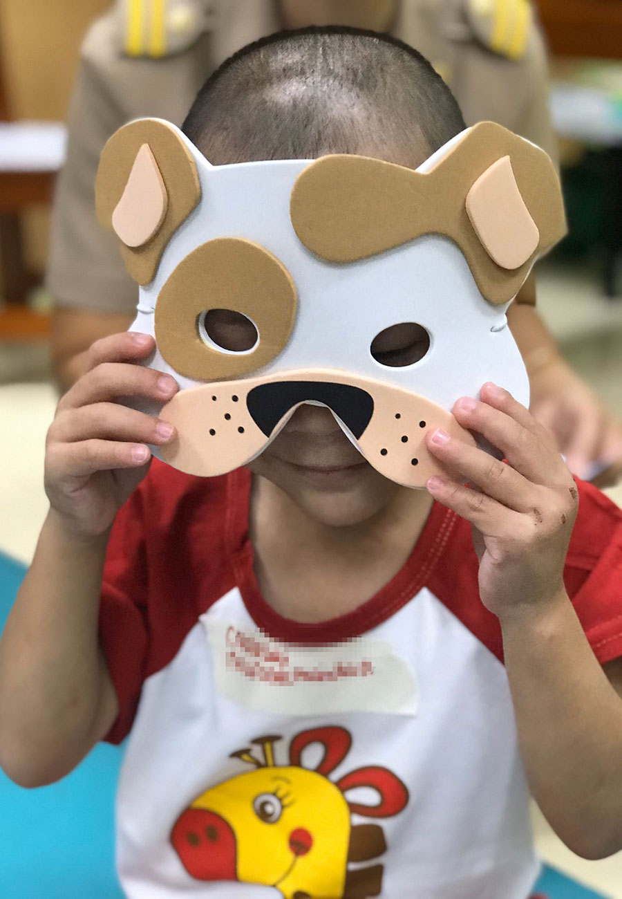 little boy wearing mask shaped like puppy dog