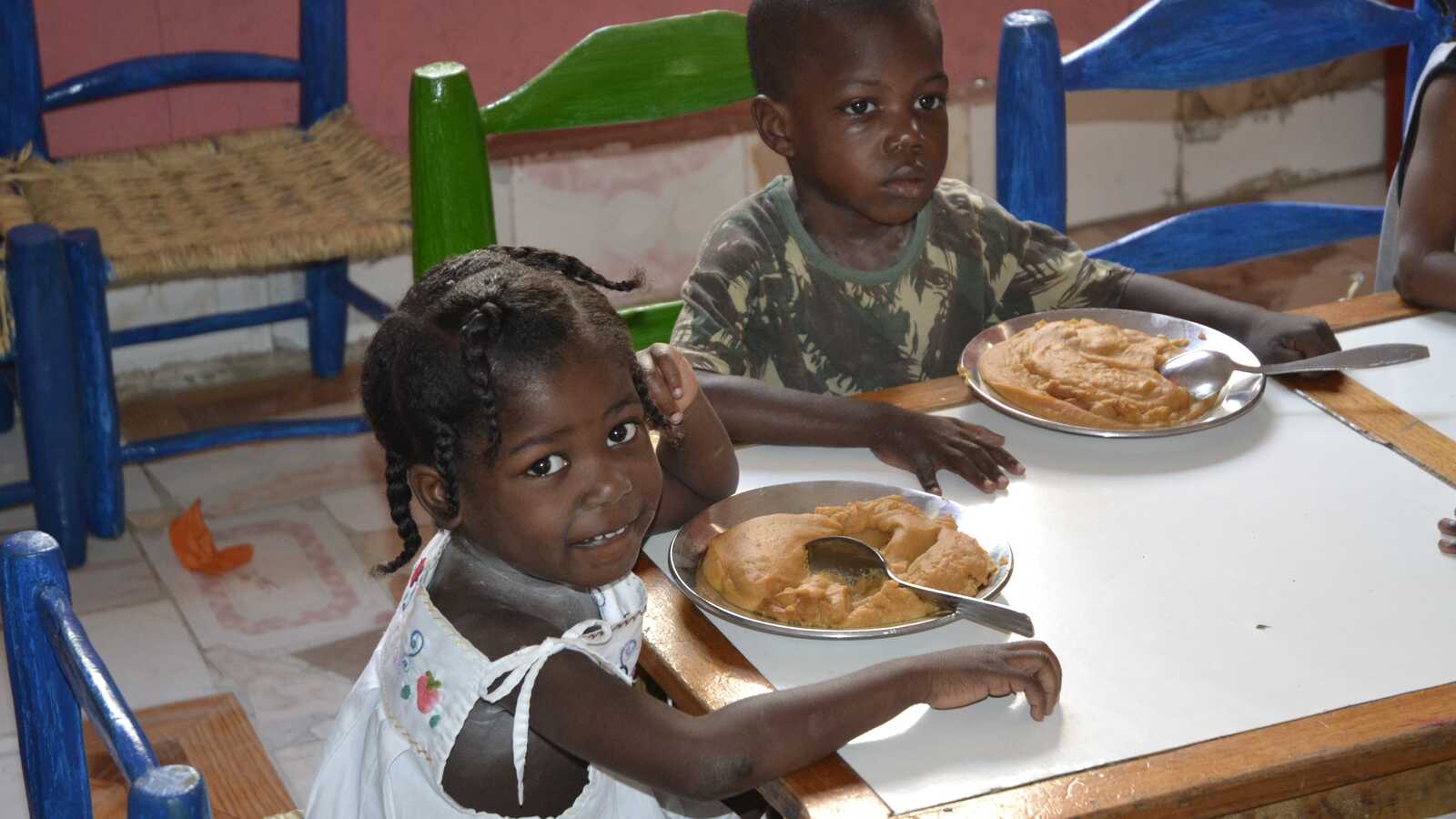 children in Haiti receiving a meal through Holt sponsorship program