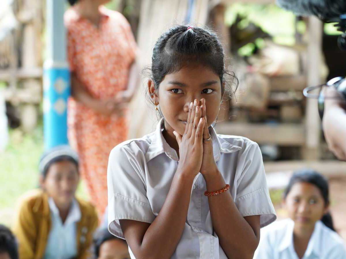 Cambodian girl with hands held palm to palm to say thank you