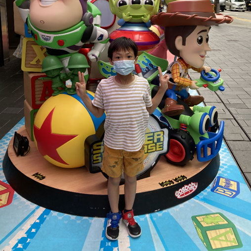 Boy in front of Disney display 