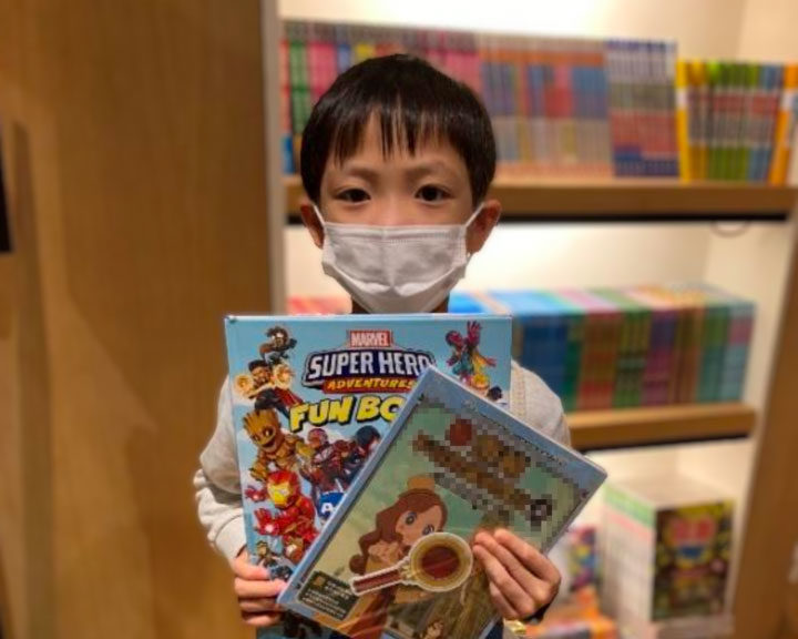 Boy holding up his books