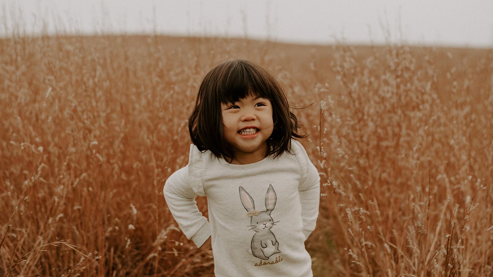 little girl smiling in orange field