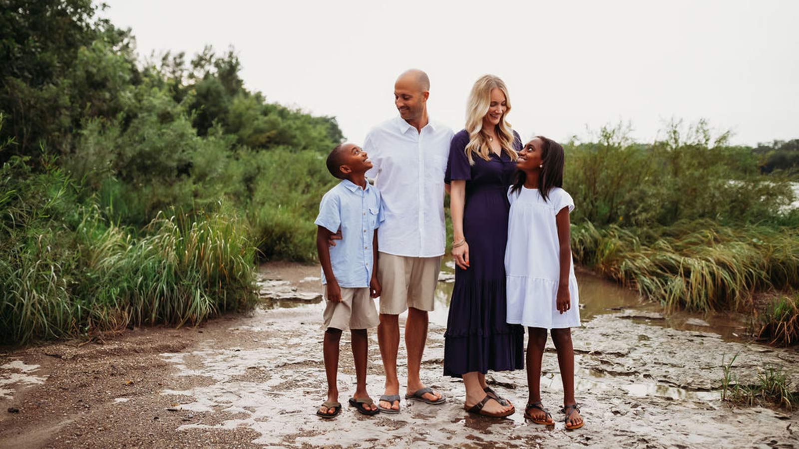 adoptive parents smiling down at children