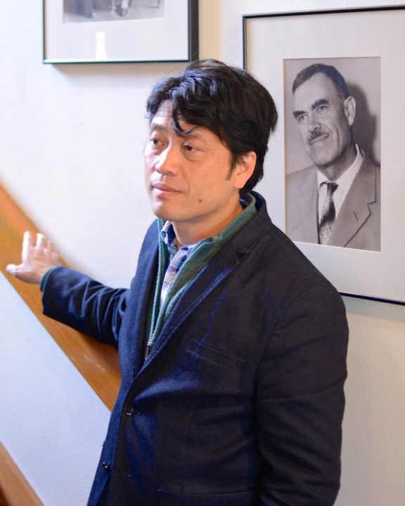 Jung Henin, artist and director of "Approved for Adoption", stands in front of a photo of Harry Holt during a tour of Holt's main office in Eugene, Oregon.