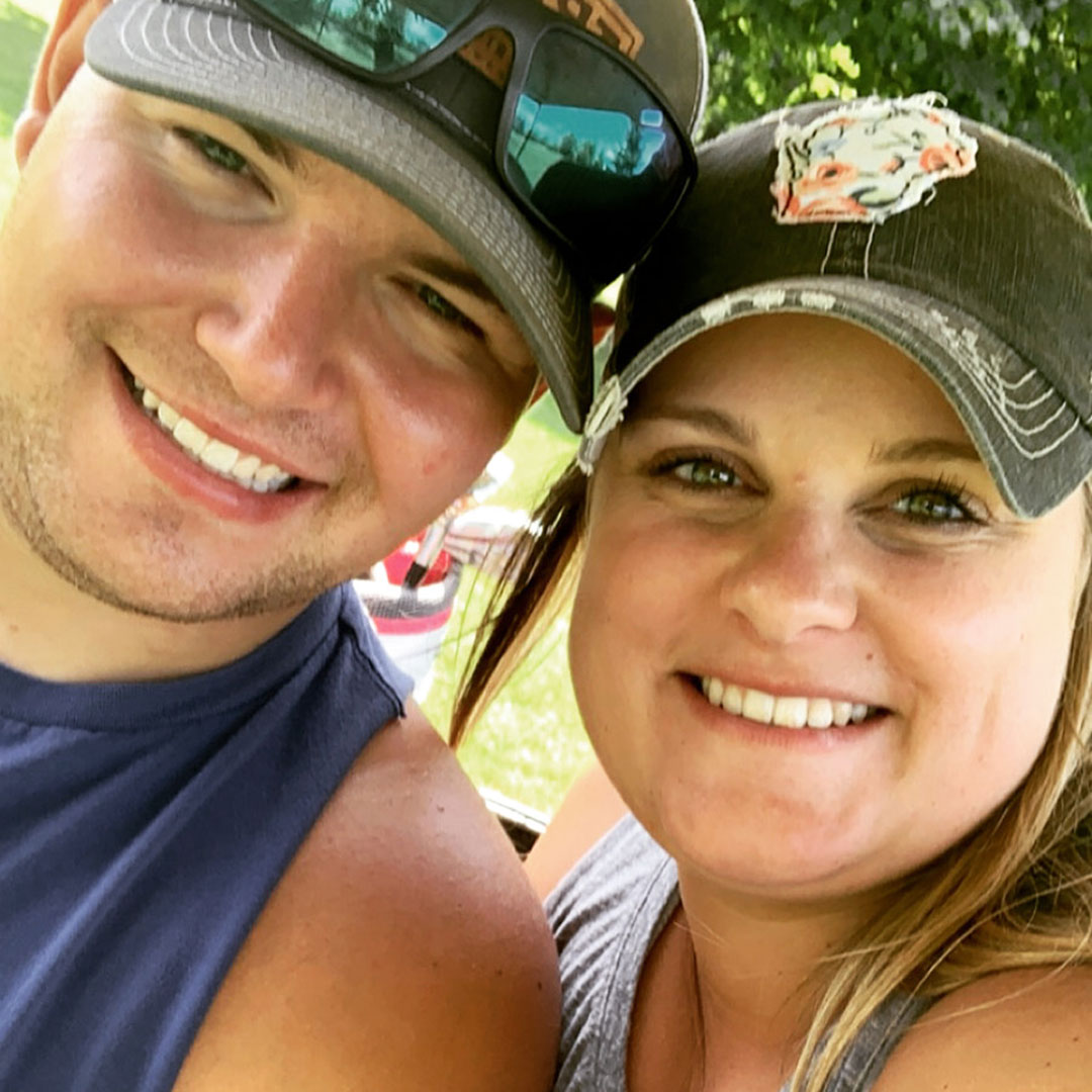 smiling man and woman in baseball hats