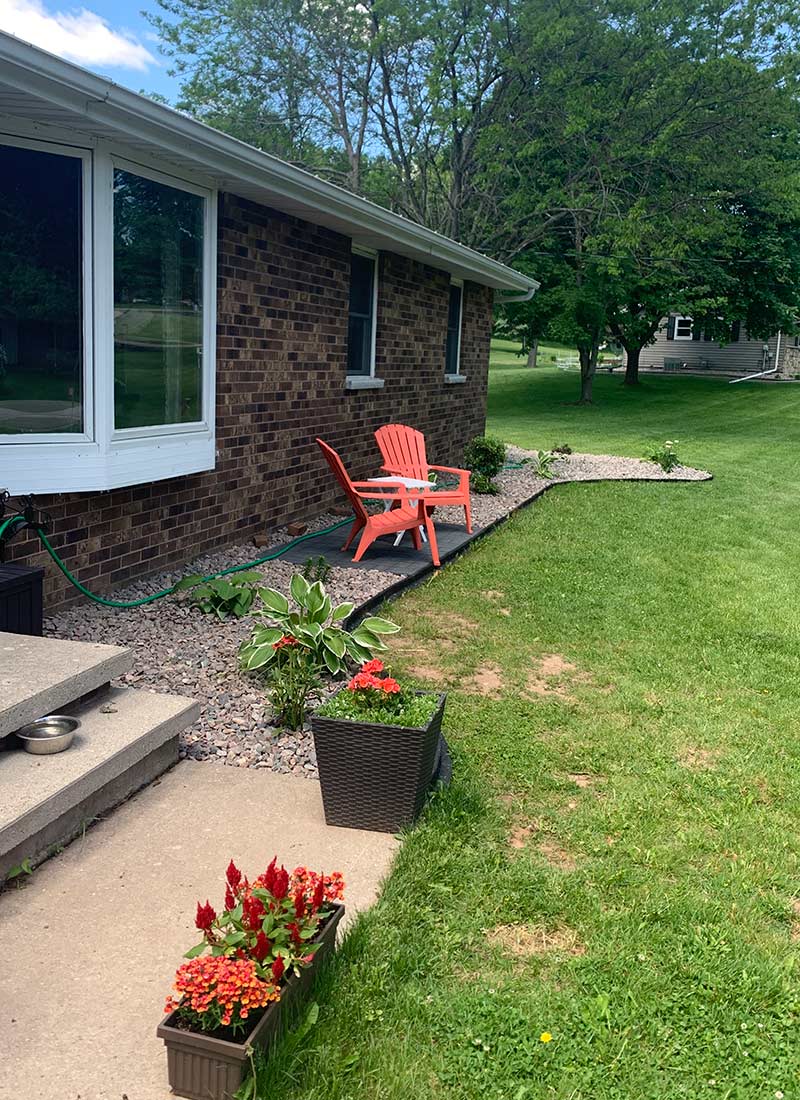 brick house with red patio chairs